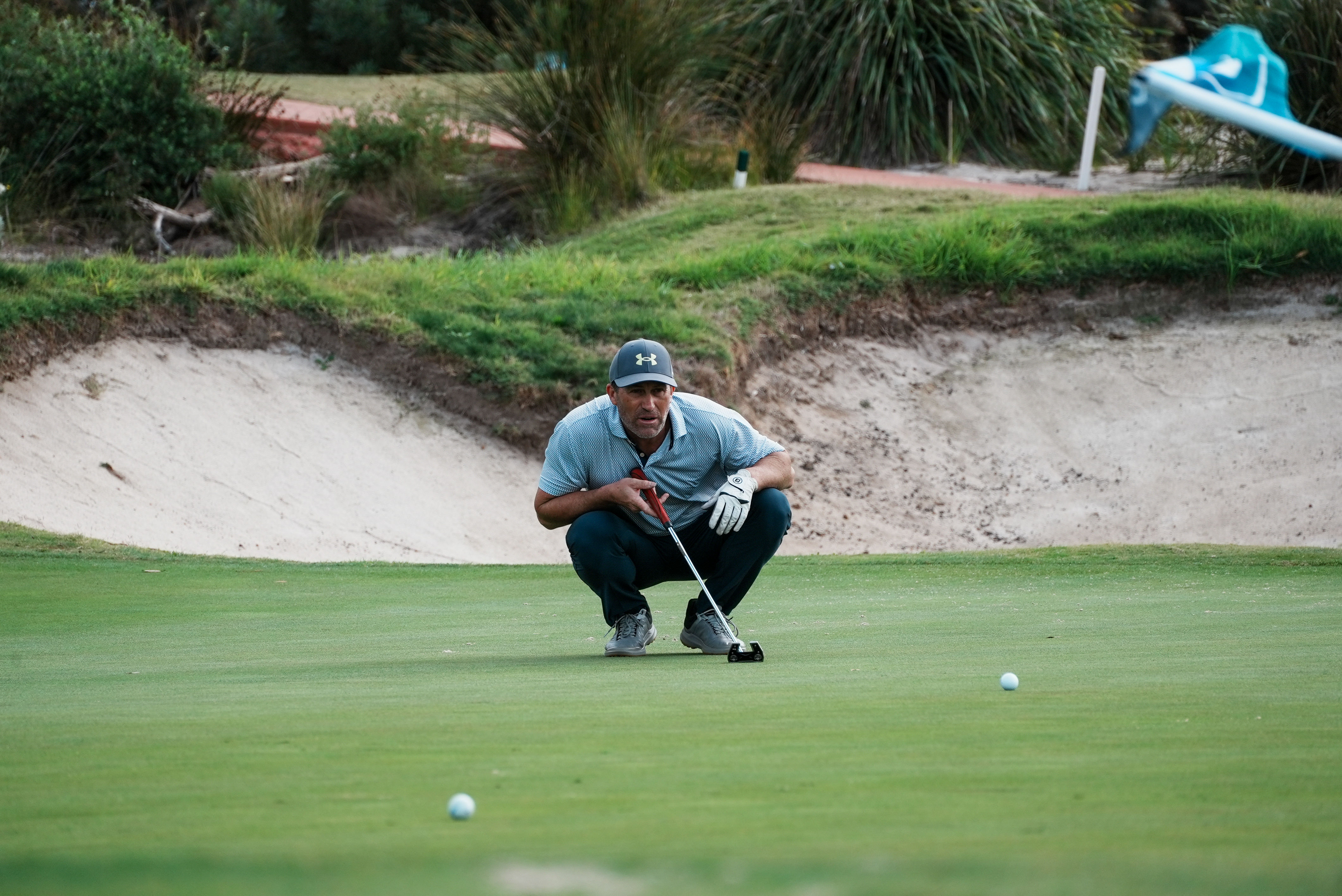 Golfer reading putt on green